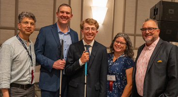 Scholarship winner Sam poses with Oracle representatives after receiving his award.